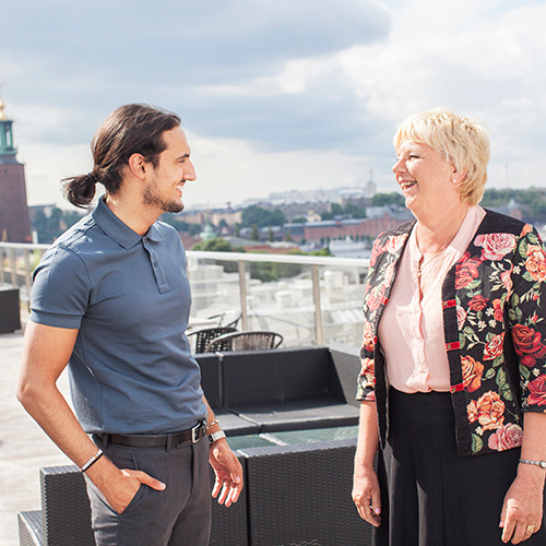 Ung kille och äldre kvinna - två medarbetare som bidrar till mångfald på arbetsplatsen.