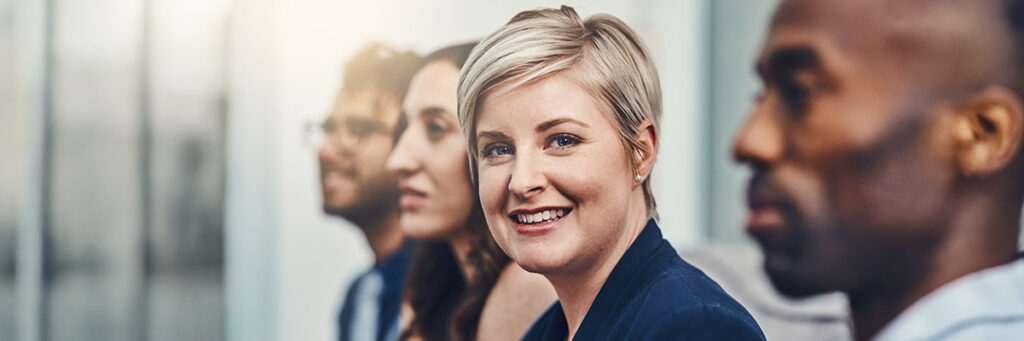 4 personer på en rad, 1 kvinna kollar in i kameran.